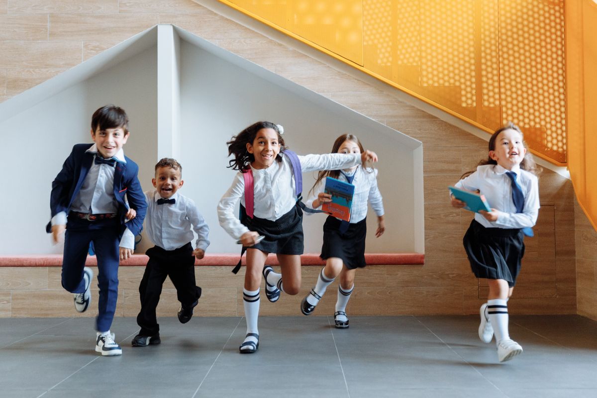Happy, diverse students in uniform at school